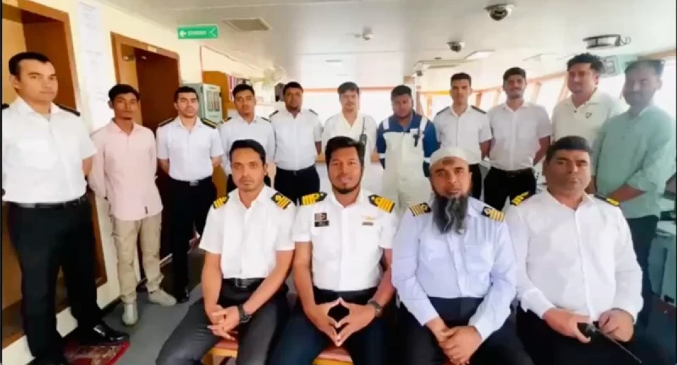 O capitão Islam, do navio Banglar Joyjatra (segundo da direita para a esquerda, na primeira fila), e o engenheiro-chefe Rashedul Hasan (à esquerda do capitão) gravam um vídeo para elevar o moral da tripulação — Foto: RASHEDUL HASAN via BBC