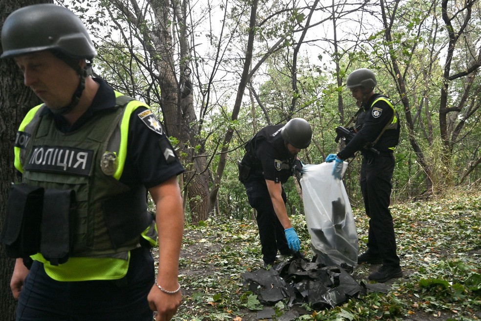 Agentes ucranianos inspecionam restos de uma arma aérea após um ataque em Kiev. — Foto: SERGEI SUPINSKY/AFP