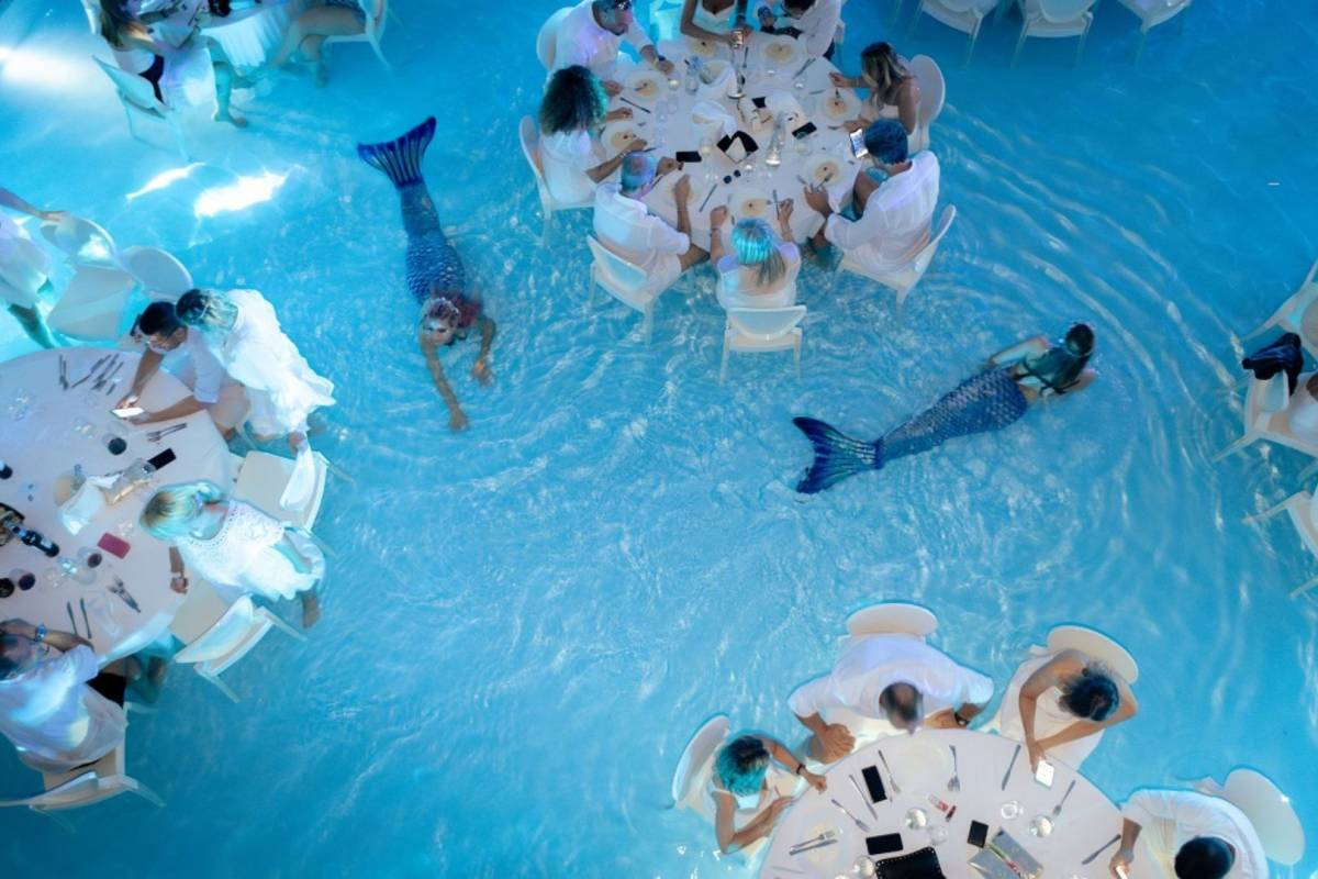 Jantar dentro de piscina com 'sereia' entre mesas viraliza e rende piadas no Brasil; conheça