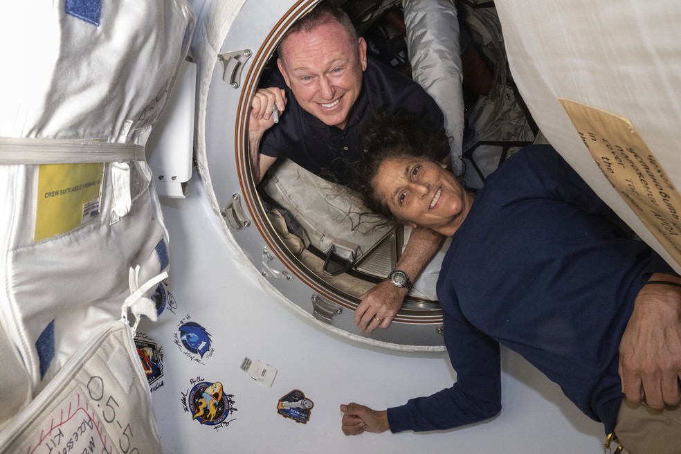 Os astronautas da Nasa Butch Wilmore e Suni Williams posam no módulo Harmony da ISS ao lado da cápsula Starliner, em 13 de junho de 2024. — Foto: Nasa
