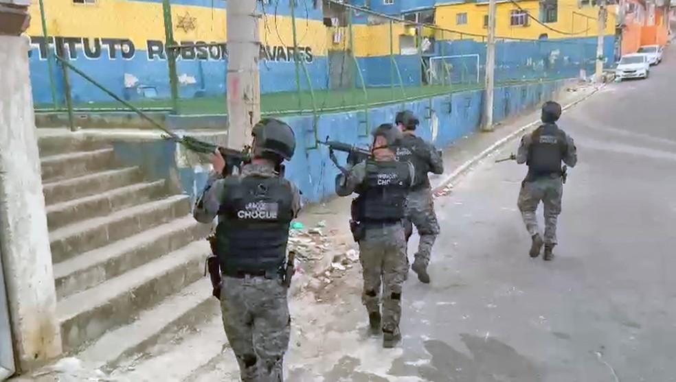 Homens do Batalhão de Choque avançam pelo Complexo de Israel — Foto: Reprodução/TV Globo