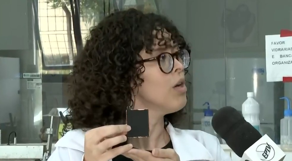 A pesquisadora da Ufla Ianca Oliveira Borges mostra um eletrodo revestido com casca de café carbonizada — Foto: Reprodução EPTV Sul de Minas