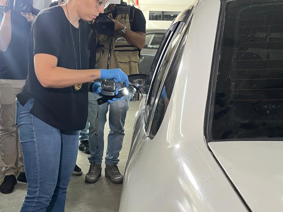 Agentes da polícia científica fazendo coletas de digitais em um dos veículos encontrados. — Foto: Giba Bergamim/ TV Globo