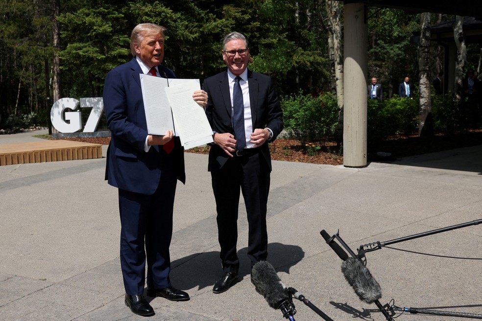 Trump segura um acordo comercial assinado com o Reino Unido durante reunião com o primeiro-ministro britânico Keir Starmer, na cúpula do G7, no Canadá. — Foto: Reuters