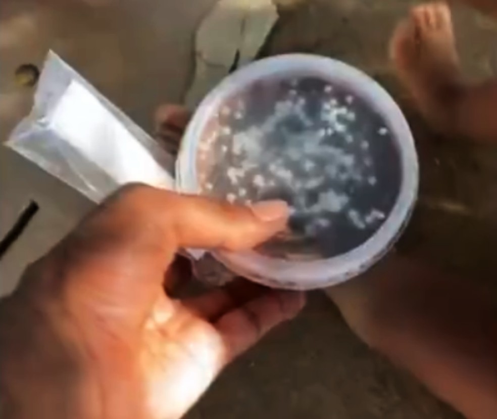 Momento em que o Maxuel entregava o bolo de pote para uma criança em situação de rua, em Salvador — Foto: Reprodução/TV Bahia