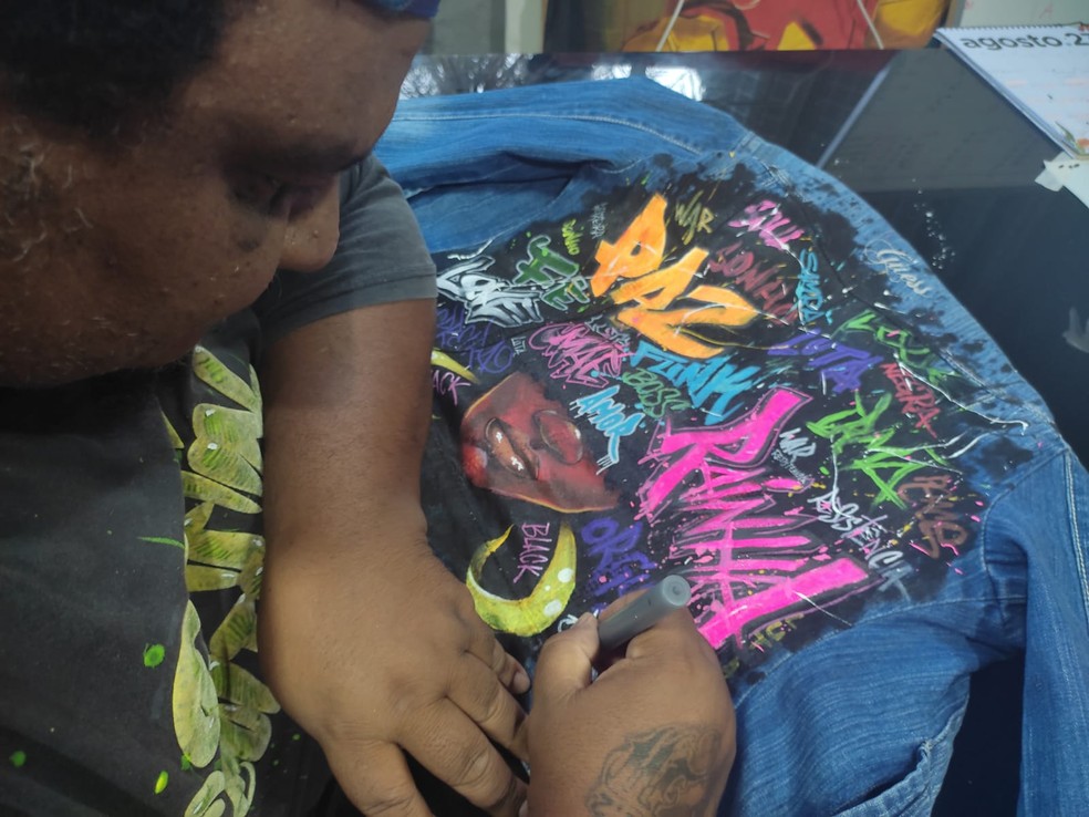 Rivas desenhando em uma jaqueta — Foto: Divulgação