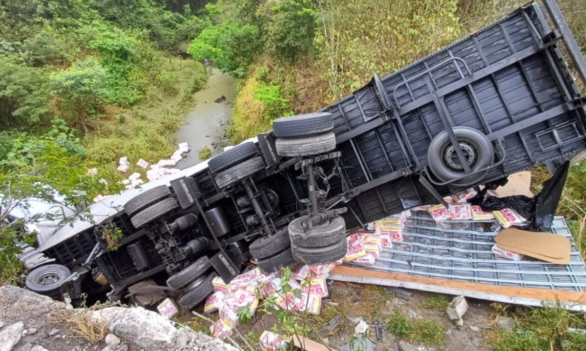 Caminhão carregado de fraldas tomba e cai em ponte na BR-116