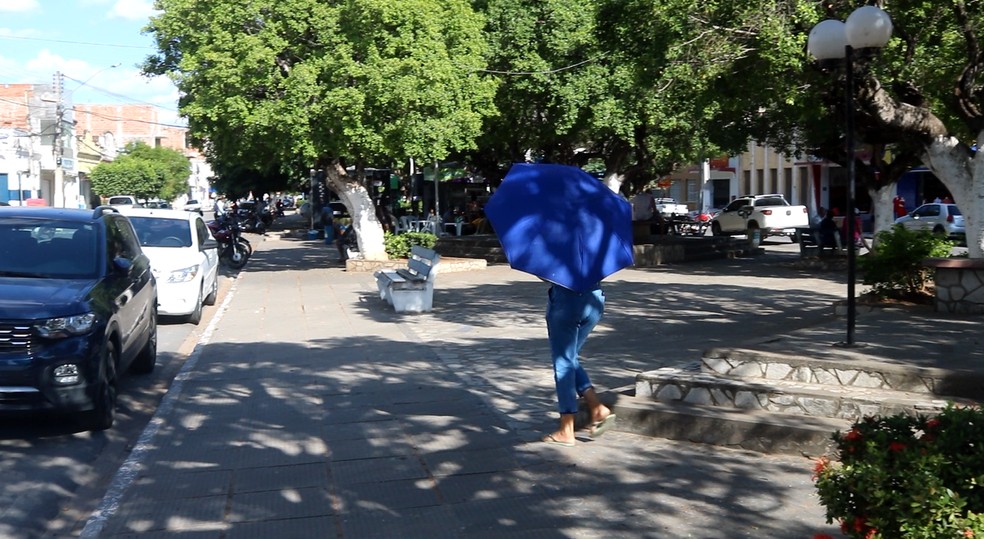 Moradores usam sombrinhas para se proteger do calor — Foto: Fagno Pinto/ Arquivo pessoal