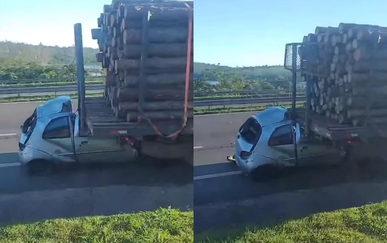 Carro fica preso embaixo de caminhão carregado com madeira após batida em rodovia no interior de SP