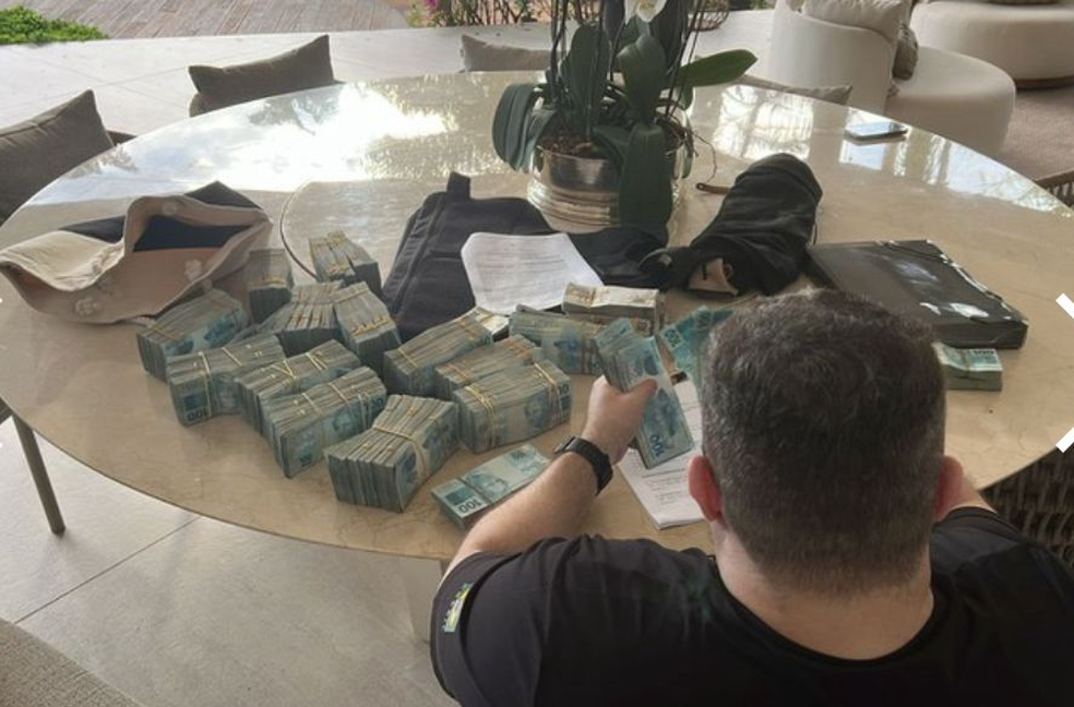 Agente da PF conta dinheiro encontrado na casa de um dos dirigentes do Banco Master — Foto: Divulgação/PF