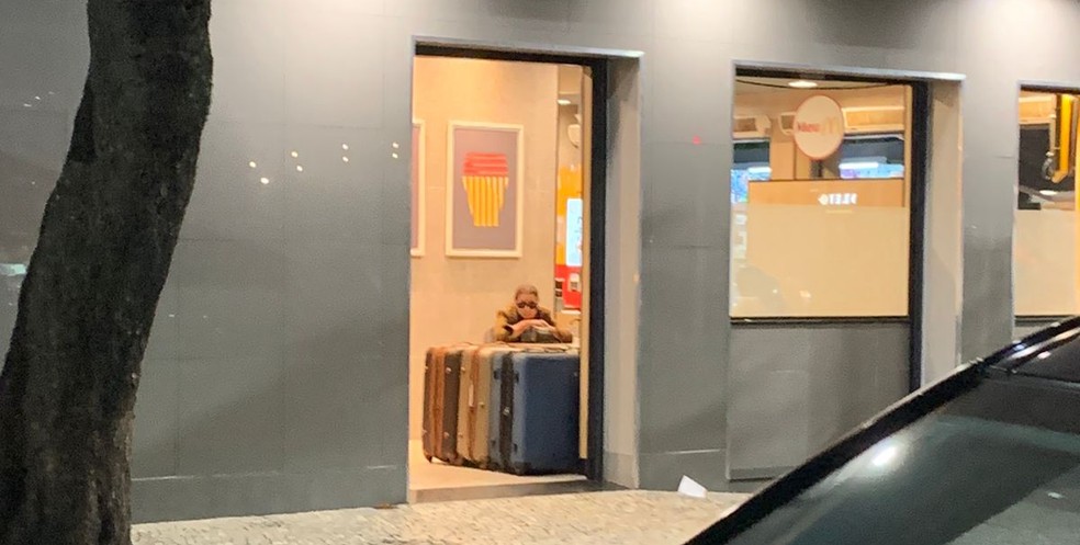 Mulher com suas malas na porta do McDonald's — Foto: g1 Rio