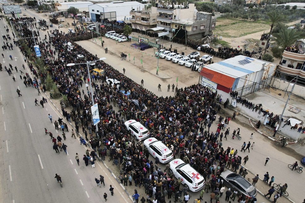 Multidão se concentra diante de palco montado pelo Hamas (ao fundo, à esquerda) para exibir reféns devolvidos pelo grupo terrorista, em 8 de fevereiro de 2025. — Foto: Mohammad Abu Samra/ AP
