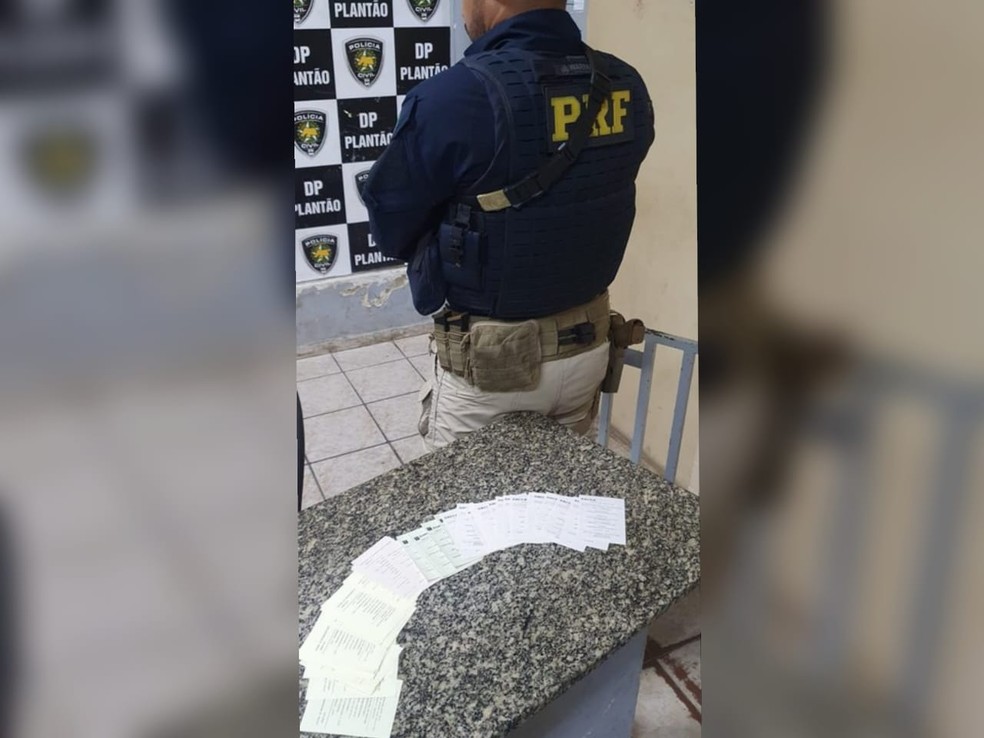Policiais apreenderam mais de 100 papéis bancários falsos com cearenses presos em Mossoró (RN) por golpes em caixas eletrônicos. — Foto: PRF/ Divulgação