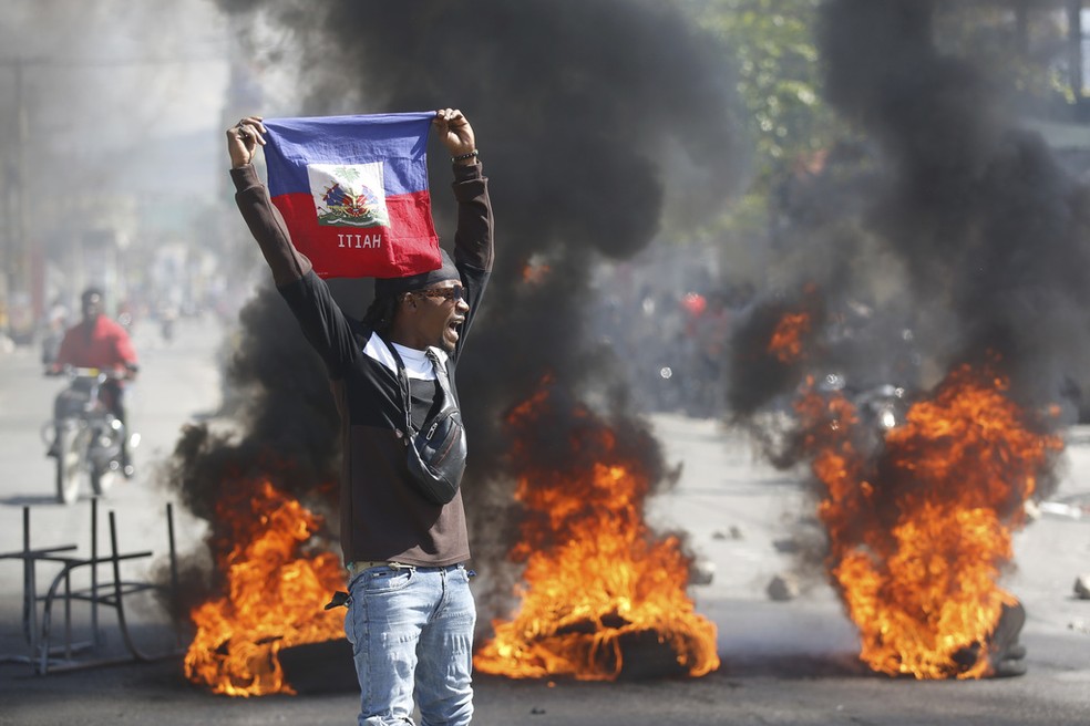 Manifestante com a baideira do Haiti em 1º de março de 2024 — Foto: Odelyn Joseph/AP