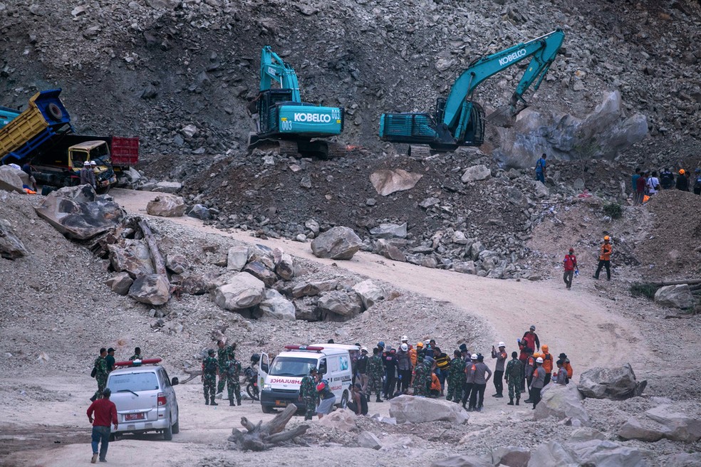 Ambulância e homens do Exército participam de trabalho de resgate em pedreira que desabou na província de Java Oriental, na Indonésia, em 30 de maio de 2025. — Foto: Okri Riyana/ AP