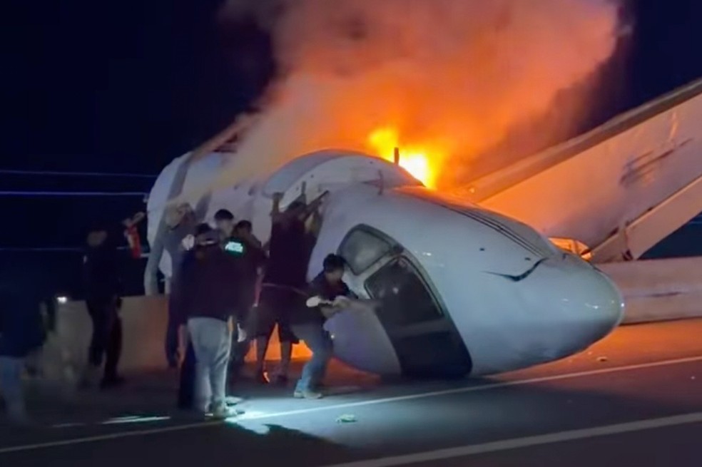 V&aacute;rias pessoas tentam retirar os ocupantes de uma pequena aeronave que caiu em uma rodovia na ter&ccedil;a-feira, 16 de junho de 2026, em Laredo, Texas. &mdash; Foto: Zayra Garza via AP