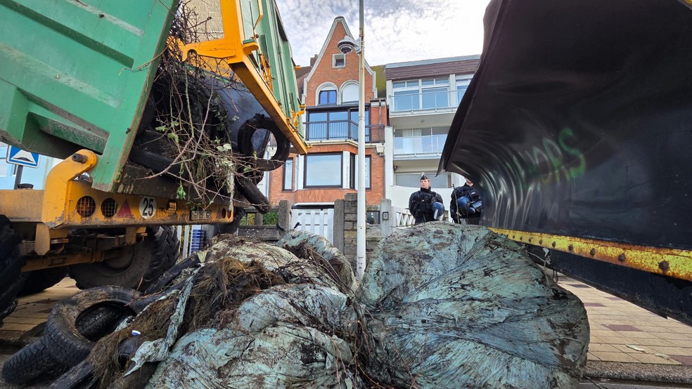 Agricultores despejam pneus e outros itens em frente à casa de praia de Emmanuel Macron, de tijolos vermelhos, em Le Toquet, na França, em 19 de dezembro de 2025 — Foto: JEROME NOEL / AFP