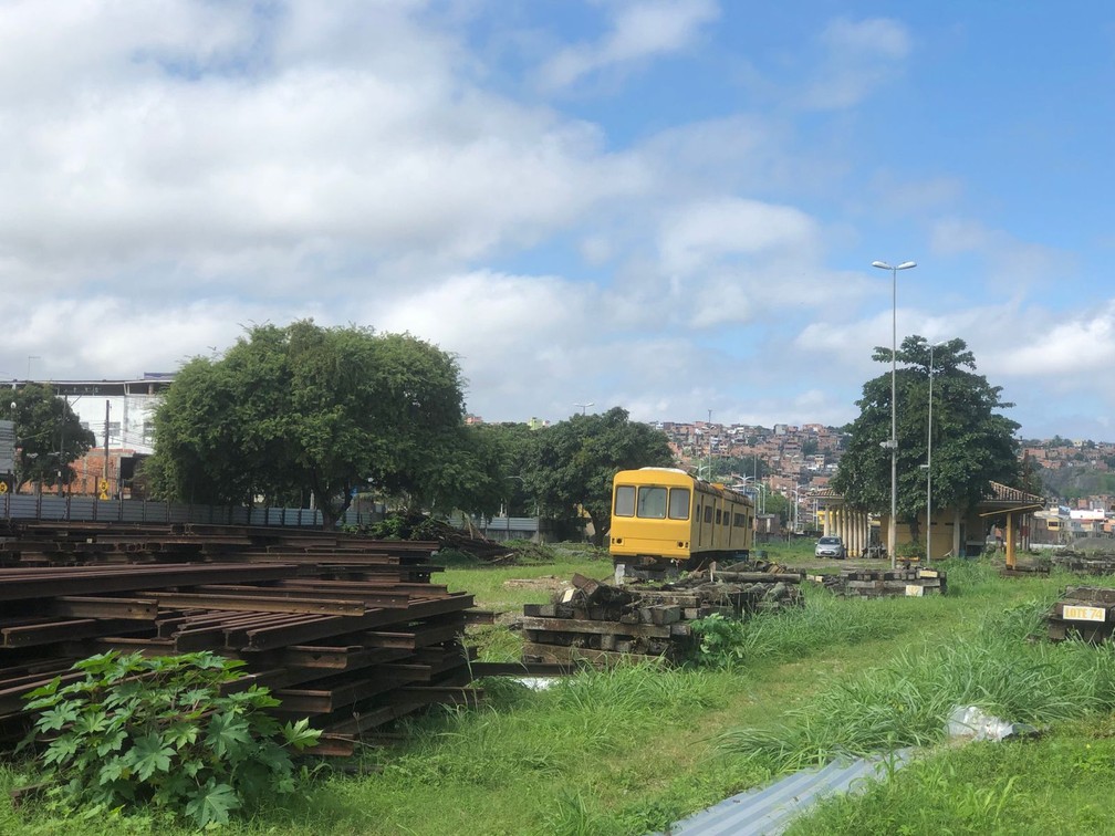 Madeiras espalhadas ao lado de  trens antigos no bairro de Periperi — Foto: João Souza/g1 BA