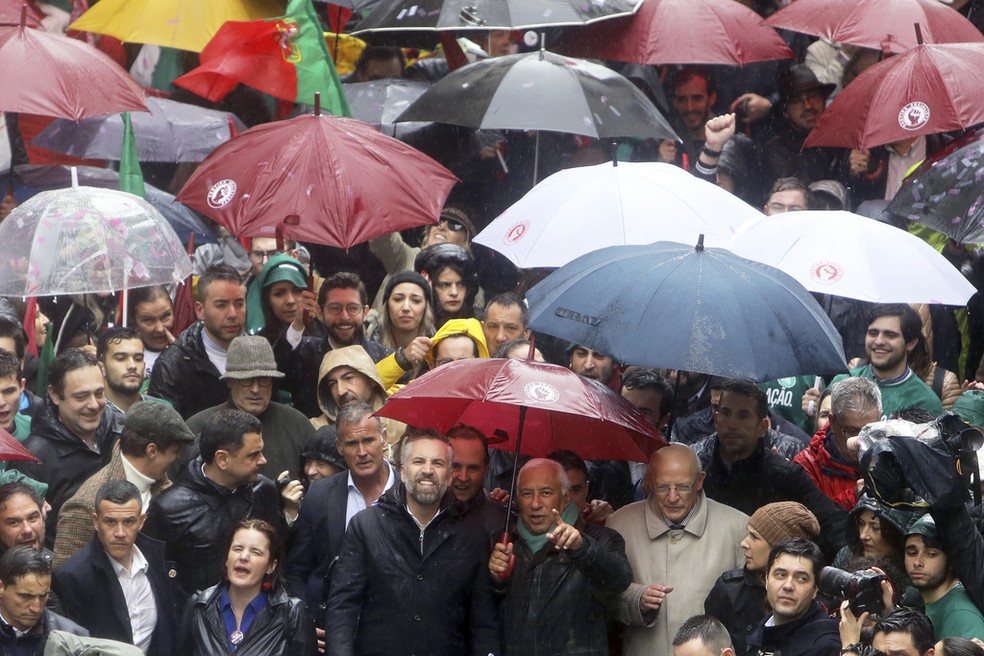O ex-premiê de Portugal António Costa (no centro, segurando o guarda-chuva), ao lado do atual líder do Partido Socialista de Portugal, Pedro Nuno Santos, em ato de campanha, em 8 de março de 2024. — Foto: Joao Henriques/ AP