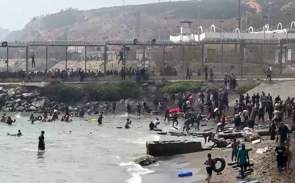 Milhares de joverns do Marrocos atravessaram o mar para chegar à fronteira marítima nesta quinta-feira — Foto: Lucia Diaz / AFP