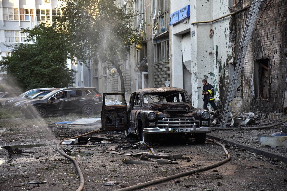 Um bombeiro trabalha no local de edifícios danificados durante ataques com drones e mísseis russos, em meio à ofensiva da Rússia contra a Ucrânia, em Lviv — Foto: Reuters