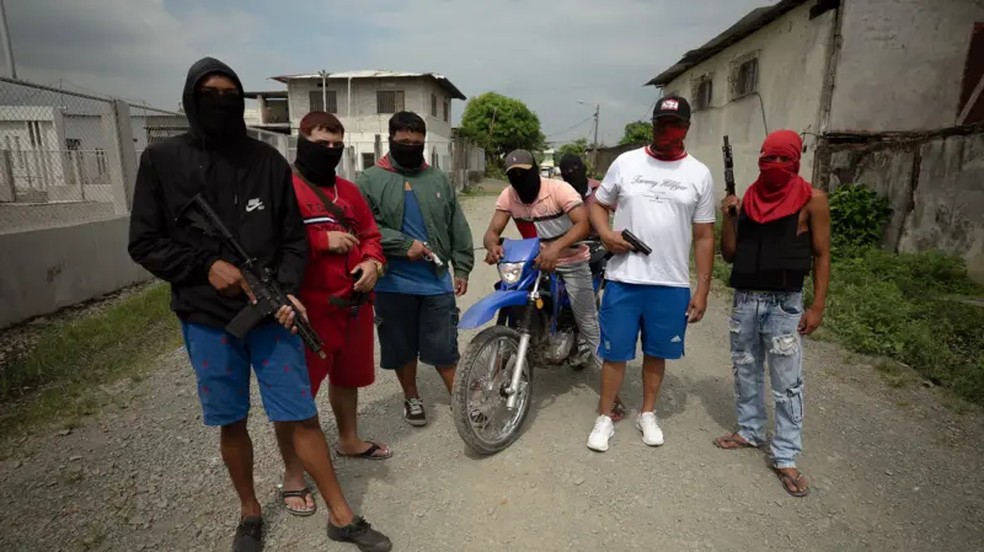 Membros de gangues andam abertamente pelas ruas com armas, em plena luz do dia — Foto: Lee Durant/BBC