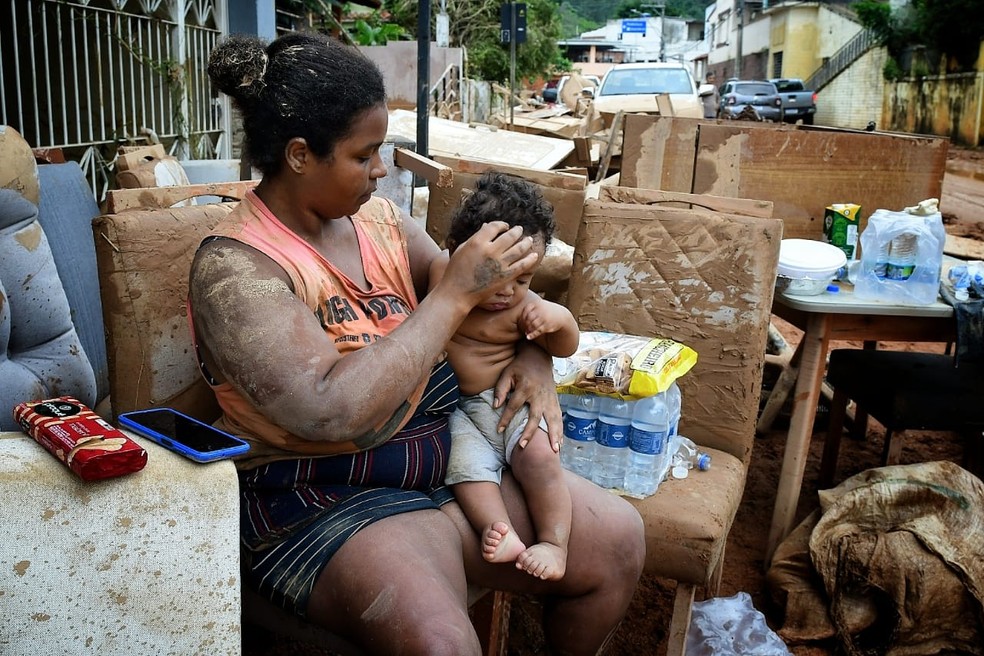 Helena Matos e o filho em meio ao cenário de destruição causado pela chuva em Mimoso do Sul, no Espírito Santo — Foto: Fernando Madeira/Rede Gazeta