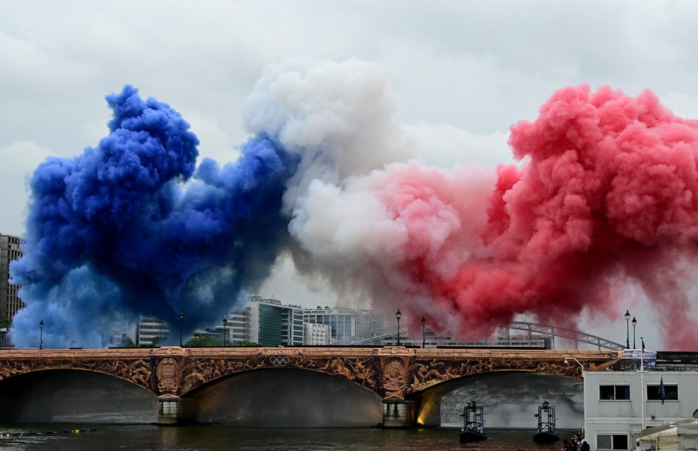 Nuvens de fumaça nas cores tricolores da bandeira da França são vistas na Pont d'Austerlitz durante a cerimônia de abertura — Foto: Angelika Warmuth/Reuters