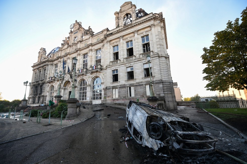 Fachada da prefeitura de Limoges com carro incendiado à frente; o prédio foi incendiado no sábado (17) — Foto: PASCAL LACHENAUD/AFP