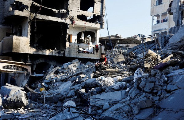 Palestino sentado no topo de escombros de uma casa atingida por um ataque israelense em Deir al-Balah, no centro de Gaza. — Foto: Mahmoud Issa / Reuters