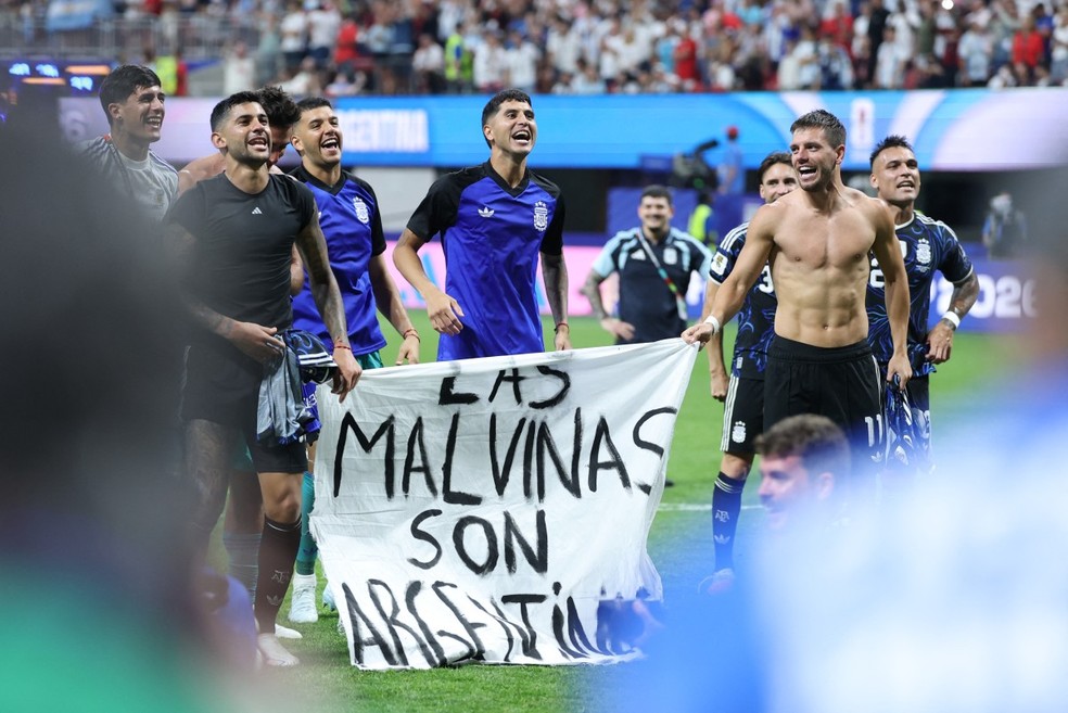Jogadores argentinos levando faixa com referência às ilhas Malvinas após eliminarem a Inglaterra da Copa do Mundo de 2026. — Foto: THOMAS COEX / AFP