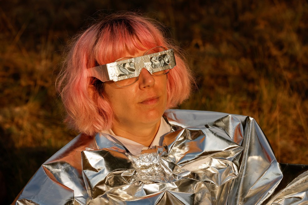 Mulher usa um equipamento improvisado para observar o eclipse solar antes da fase de totalidade, perto do vilarejo de Castell de Cabres, na Espanha, nesta quarta-feira (12). — Foto: Eva Manez/Reuters