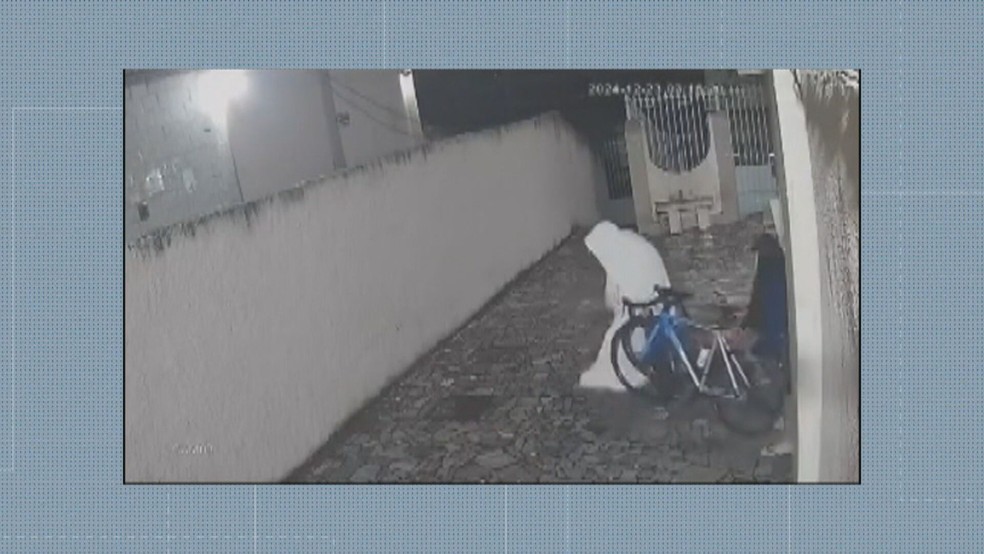 Ladrão usa lençol para se esconder e furtar bicicletas — Foto: Reprodução/TV Globo