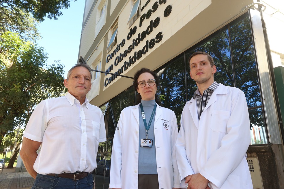 Parte da equipe responsável pelo desenvolvimento do dispositivo: Elinton Chaim, à esqueda; Raquel Leal, ao centro; e Fábio Chaim, à direita. Pesquisadores estão em frente ao Centro de Pesquisa em Obesidade e Comorbidades, coordenado por Lício Velloso. — Foto: Pedro Amatuzzi/Inova Unicamp