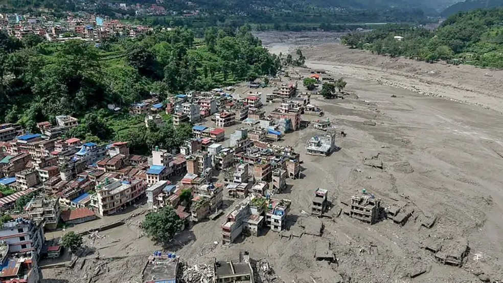Casas encontram-se parcialmente submersas em &aacute;guas barrentas &agrave; beira de um rio ap&oacute;s inunda&ccedil;&otilde;es repentinas em Trishuli Bazar, no distrito de Nuwakot, no Nepal &mdash; Foto: Prabin Ranabhat/AFP via Getty Images