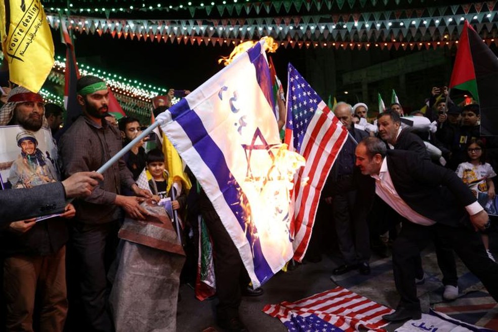 Manifestantes queimam bandeiras dos EUA e de Israel durante um protesto em Teerã, Irã, 1º de abril de 2024 — Foto: Reuters