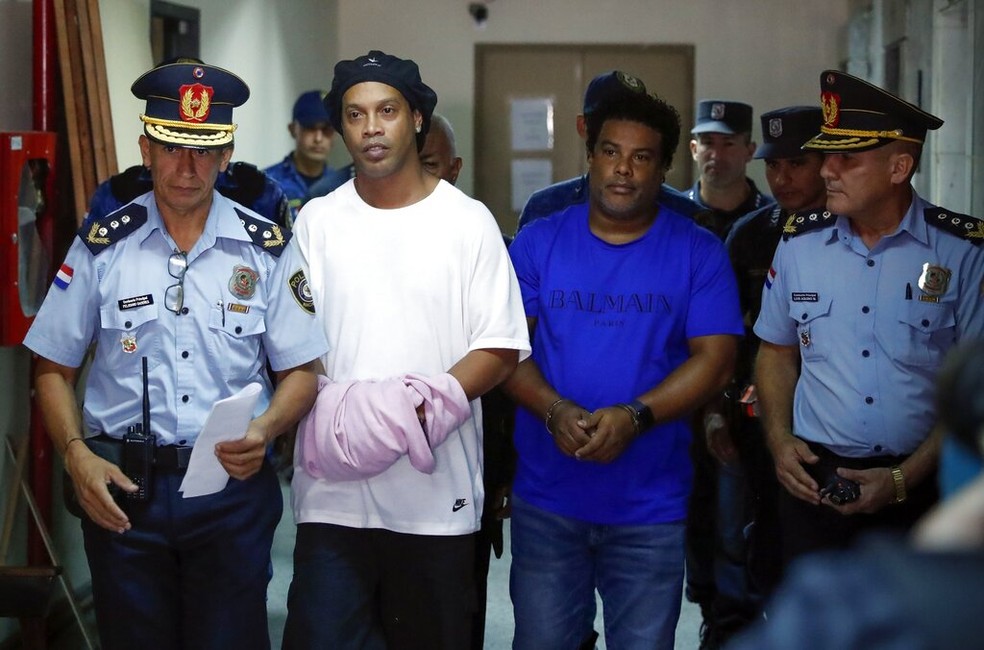 Ronaldinho Gaúcho de algemas para prestar depoimentos no Paraguai, em 7 de março — Foto: Jorge Saenz/AP