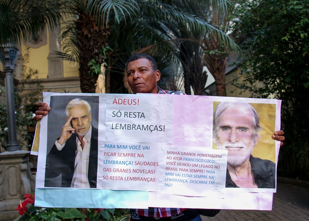 Fã segura um cartaz e faz homenagem em frente ao local onde o ator Francisco Cuoco está sendo velado no bairro da Bela Vista, na região central da capital paulista. — Foto: RAUL LUCIANO/ATO PRESS/ESTADÃO CONTEÚDO