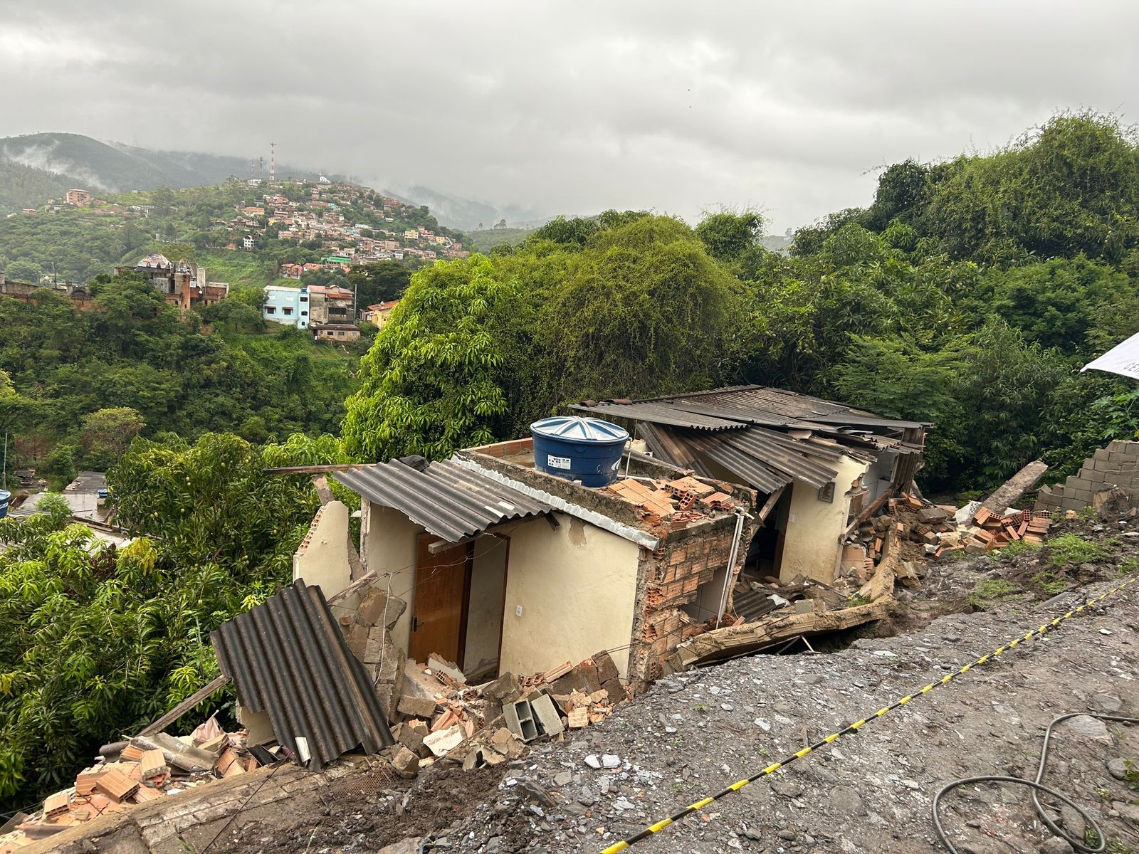 Criança de 5 anos e quatro adultos são atingidos após após barranco deslizar sobre casa na Grande BH