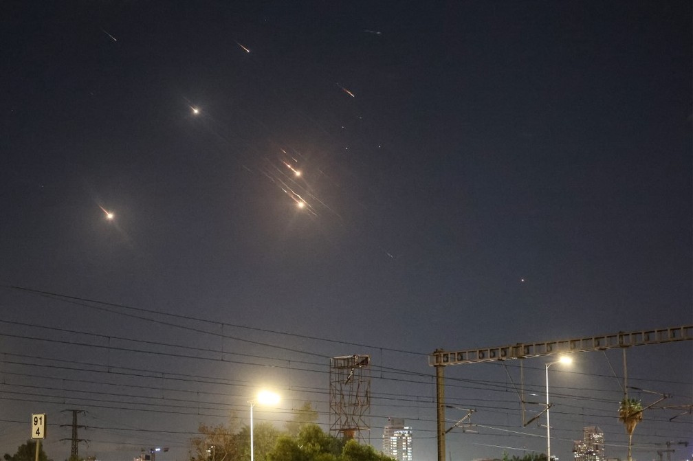 Fotos mostram projéteis lançados pelo Irã sendo interceptados sobre o céu Tel Aviv, em Israel — Foto: Jack Guez/AFP