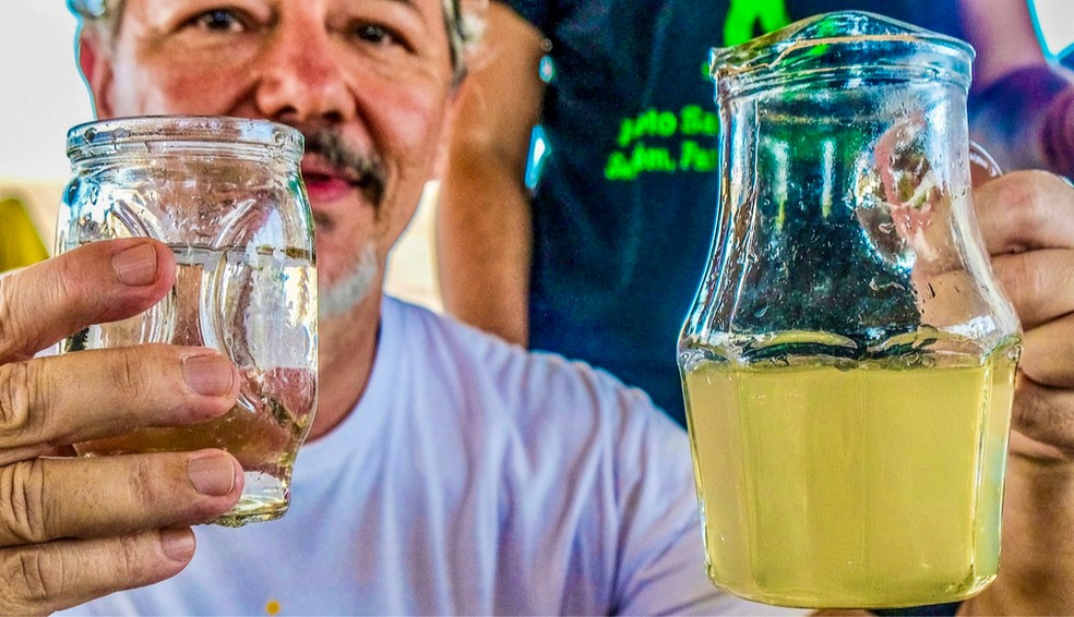 Caetano Scannavino mostra a mudança na coloração da água com o uso do filtro de nanotecnologia doado para comunidades — Foto: Ascom PSA