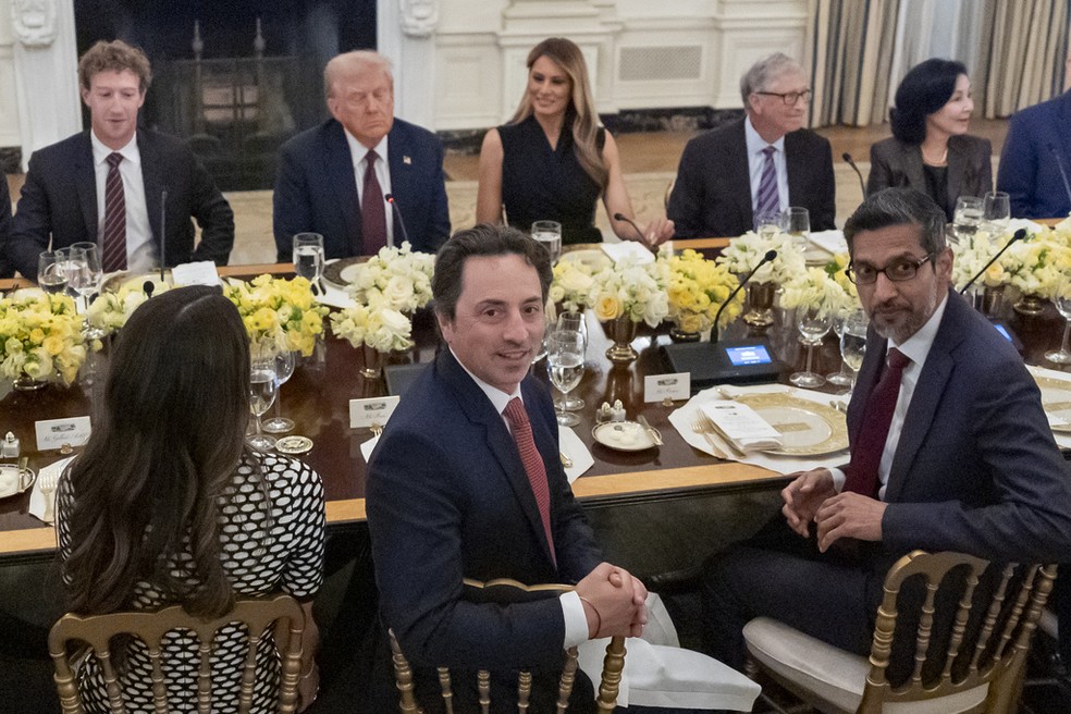 (Virados para a câmera) Sergey Brin, um dos fundadores do Google, e Sundar Pichai (à dir), CEO da big tech, participam de jantar com Donald Trump (ao fundo) e outros líderes do setor de tecnologia, na Casa Branca, em 4 de setembro de 2025 — Foto: Alex Brandon/AP