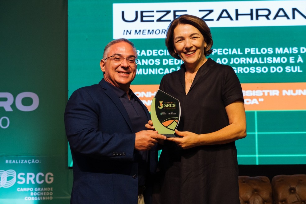 Presidente do SRCG, Alessandro Coelho, entrega troféu que homenageia Ueze Zahran a filha do empresário, Ana Karla Zahran — Foto: Agroa/Divulgação