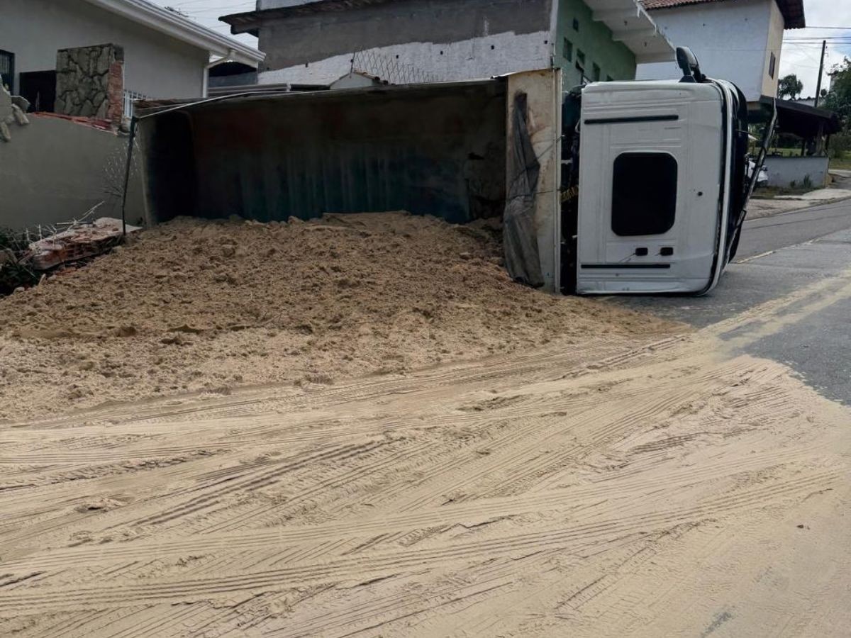 Caminhão carregado com areia tomba após bater contra muro de casa em Vinhedo