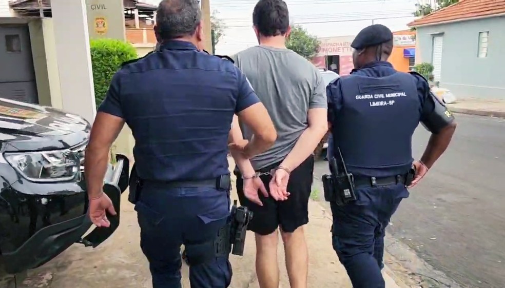 Guardas conduzem o suspeito após a prisão — Foto: Wagner Morente