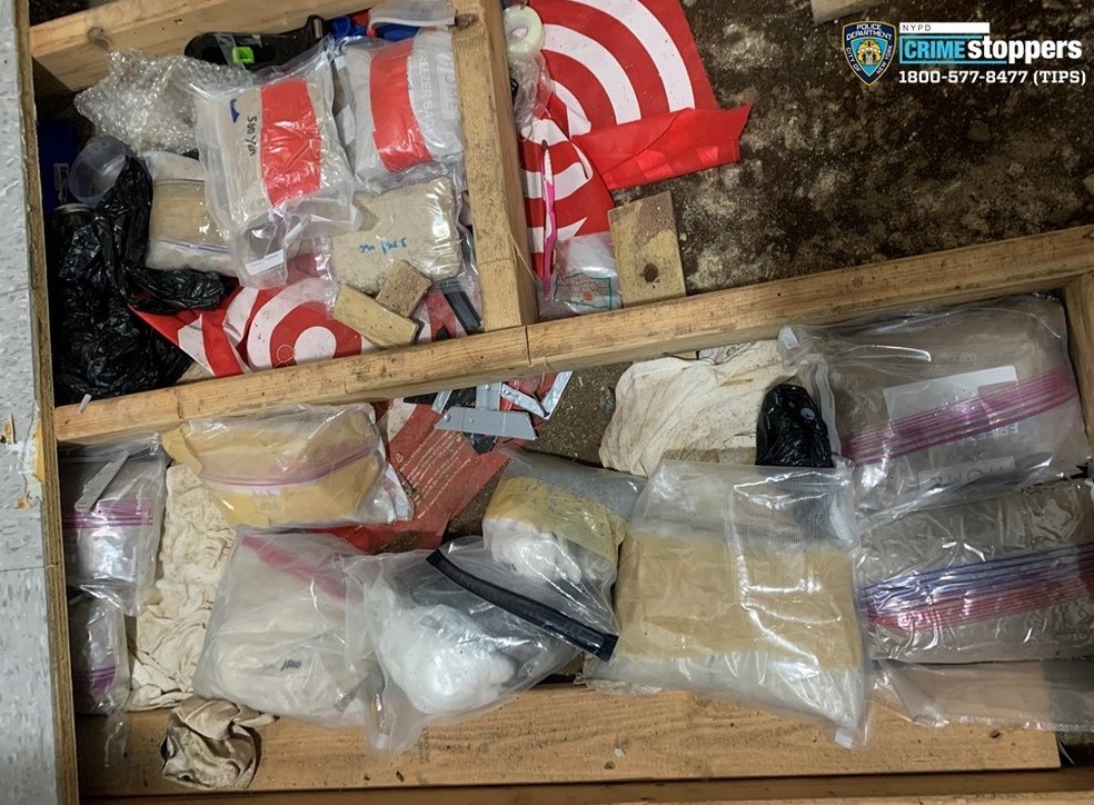 Drogas são vistas em alçapão no meio de um apartamento que funcionava como centro de cuidado para crianças, no Bronx — Foto: Reprodução/NYPD