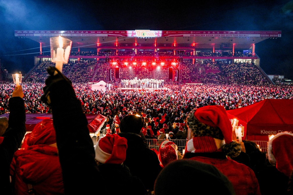 Torcedores do clube alemão de futebol 1. FC Union Berlin seguram velas enquanto se reúnem no Stadion An der Alten Försterei para cantar canções tradicionais de Natal, em Berlim, na Alemanha. — Foto: Reuters/Annegret Hilse
