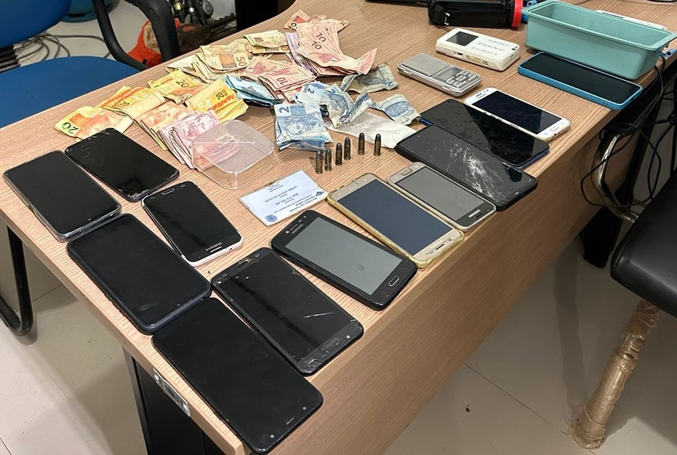Celulares, dinheiro e outros objetos apreendidos com suspeito — Foto: PM/Divulgação