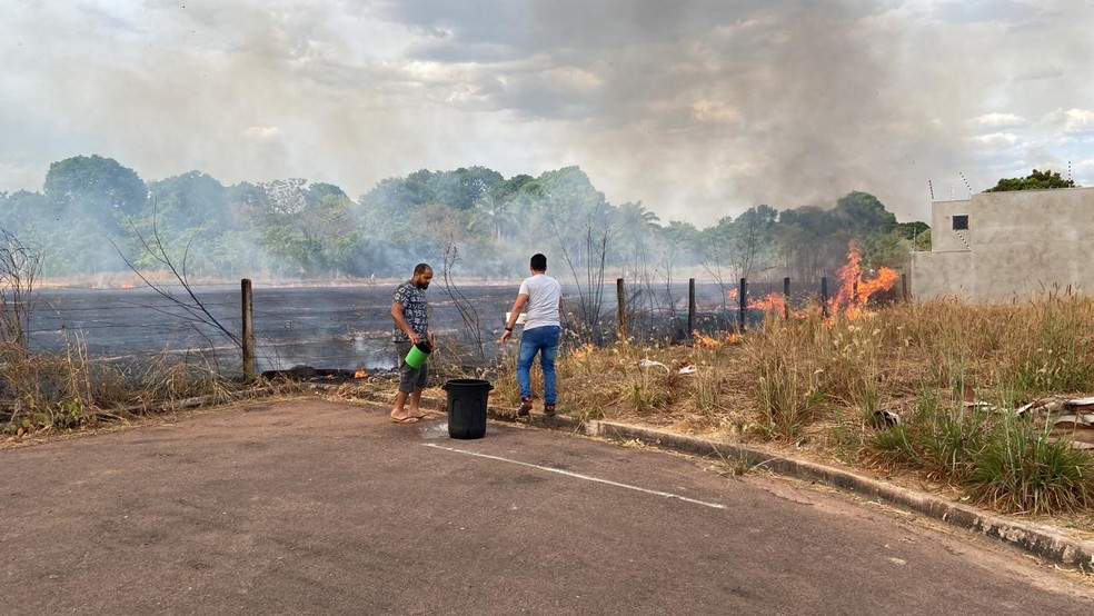 Moradores tentam controlar o fogo com baldes e utensílios improvisados — Foto: Anderson Hentges