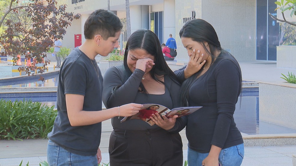 Família de Anna Júlia vendo fotos da criança. — Foto: TV Globo